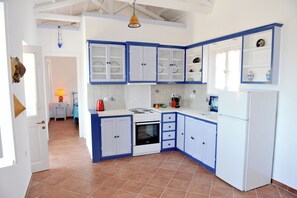 Eine Küche mit weißen Schränken, einem Herd und einem Kühlschrank.