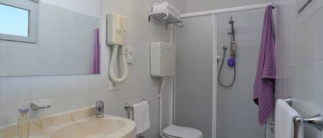 A bathroom with a sink, toilet, and shower.
