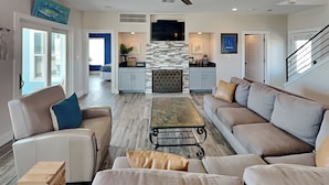 A spacious living room with a sofa, coffee table, and a fireplace.