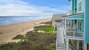 A beachfront property with a balcony overlooking the ocean.