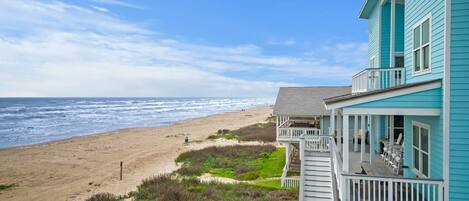 A beachfront property with a balcony overlooking the ocean.