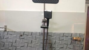 Eine Dusche mit Duschkopf und Handbrause.