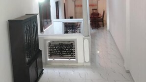 Ein geräumiges Zimmer mit Fliesenboden, einem schwarzen Schrank und einer weißen Theke mit einer verzierten Grillleiste.