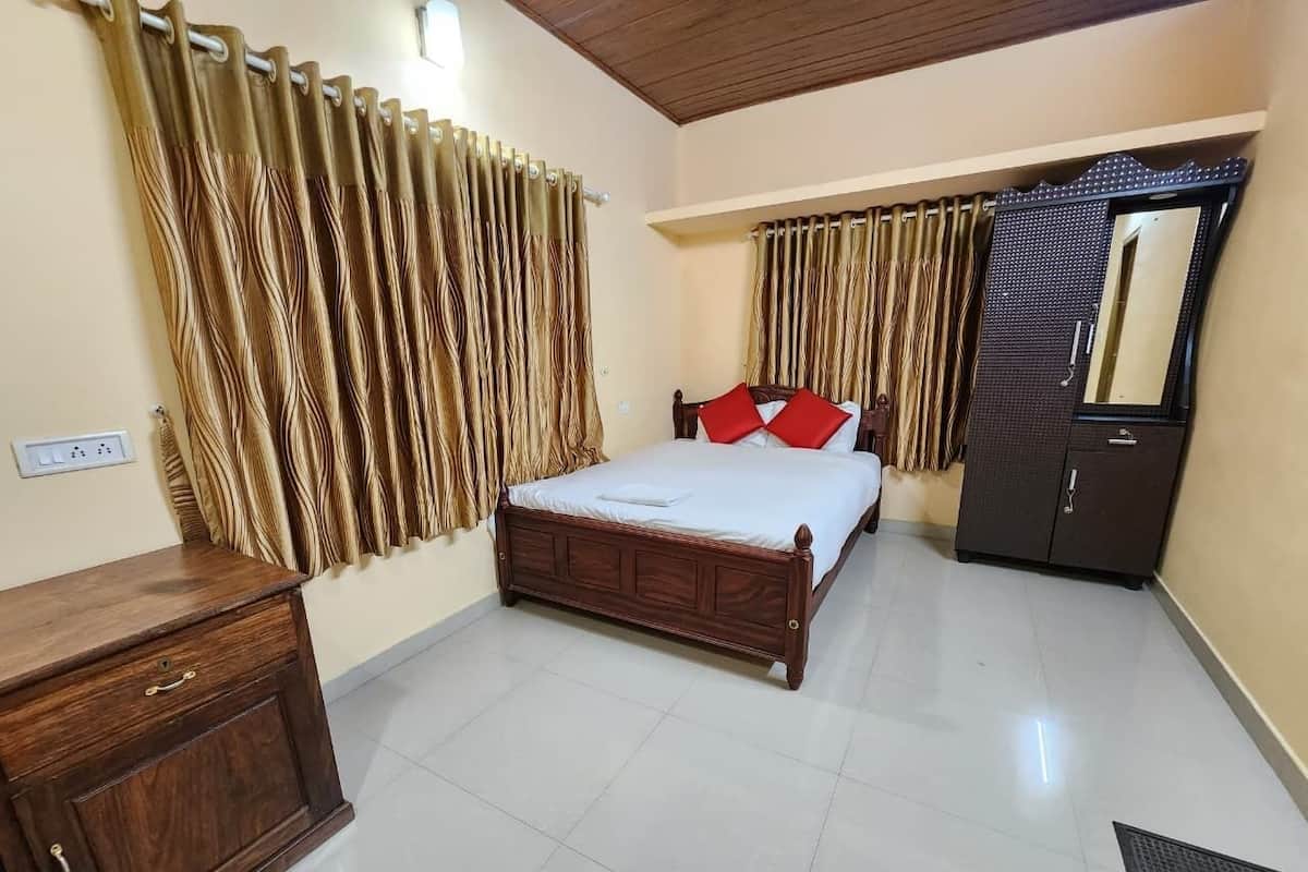 A bedroom with a wooden bed, a wardrobe, a mirror, and curtains.