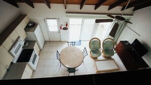 Una cocina con una mesa redonda, sillas y un ventilador de techo.