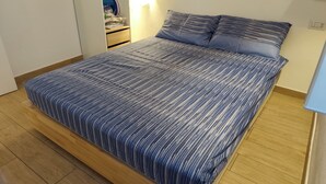 A bedroom with a bed, wooden flooring, a nightstand, and a wall-mounted shelf. - Stay in the heart of Tropea - the sea is just a 5-minute walk away (Tropea)