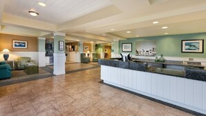 A hotel lobby with a reception desk, seating area, and a tiled floor. - Long Beach WA | Coastal Family Retreat | Pool + Hot Tub | 2BR (Long Beach)