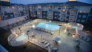 A hotel courtyard with a swimming pool, sun loungers, and a fenced area. - Long Beach WA | Coastal Family Retreat | Pool + Hot Tub | 2BR (Long Beach)