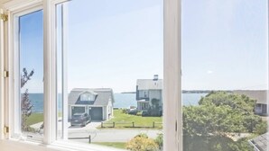 A view from a window overlooking a residential area with houses and a body of water. - Expansive Family Home with Water Views (Marion)