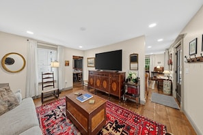 A living room with a sofa, a coffee table, a TV, and a cabinet.