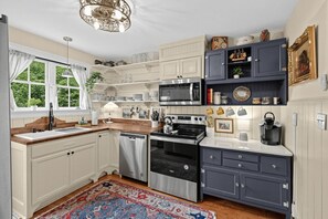 A kitchen with white cabinetry, a microwave, a stove, and a dishwasher.