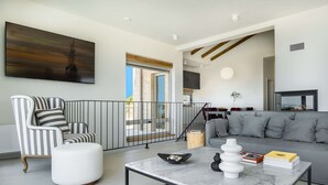 A modern living room with a striped armchair, a grey sofa, a marble coffee table, and a painting on the wall. - 5* Luxury Seaview Villa Plant 6 with pool (Novalja)