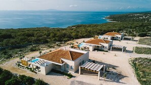 A coastal resort with modern villas, a swimming pool, and a view of the sea. - 5* Luxury Seaview Villa Plant 6 with pool (Novalja)