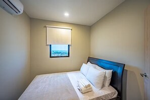 A hotel room with a bed, a window with a view, an air conditioning unit, and a door. - 7 Bedroom Penthouse Mountain & Ocean Views JB21001 (Jaco)