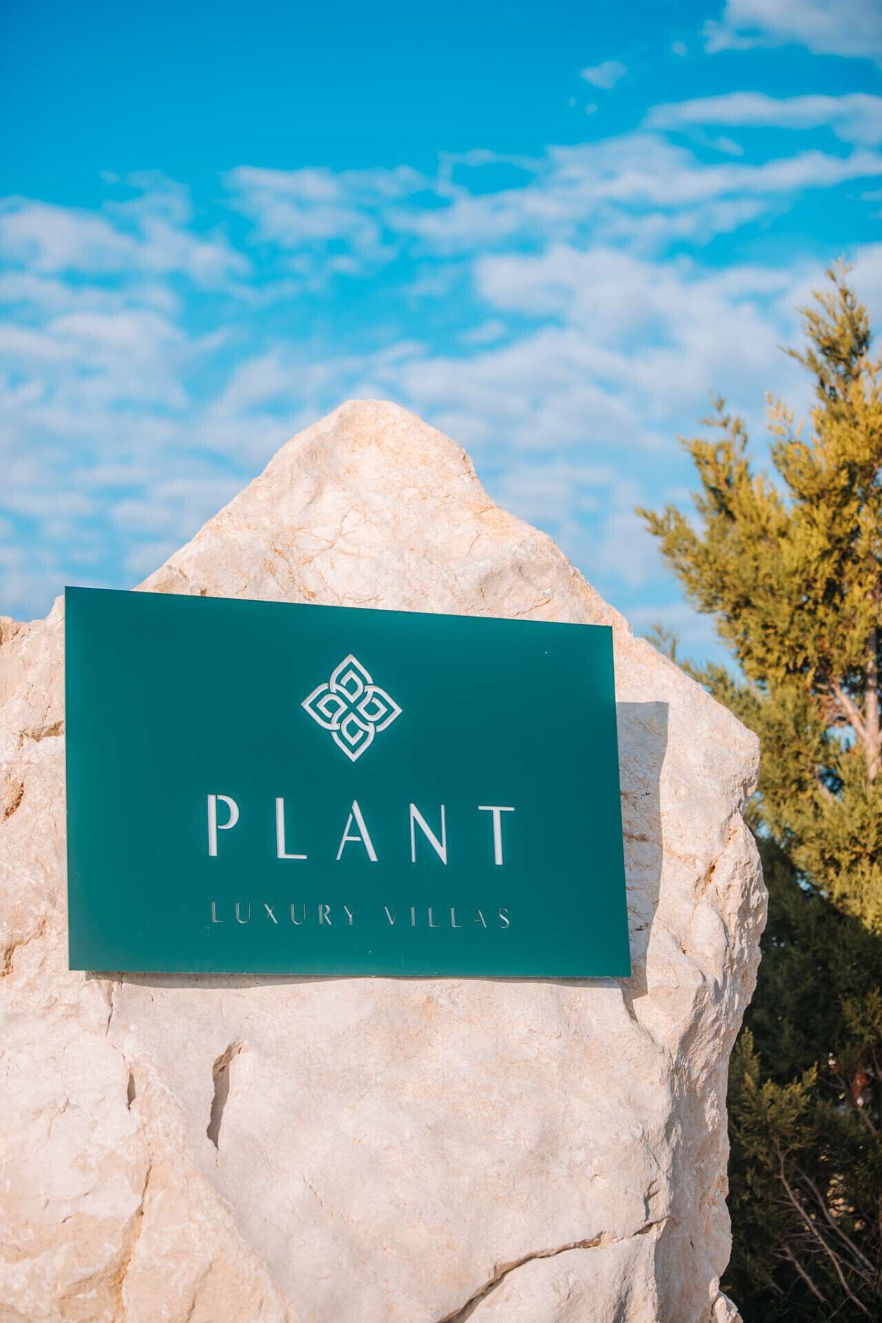 Et skilt på en klippe med teksten 'PLANT LUXURY VILLAS'.