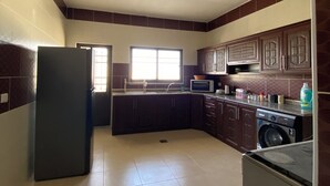 Una cocina equipada con refrigerador, microondas, lavadero y lavadora.