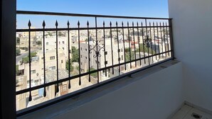 Un balcón con barandilla de metal que da a una zona residencial.
