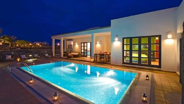 A swimming pool with a sunken seating area, a covered patio, and a view of the sea. - Playas Blanca Pool Private Villas (Yaiza)