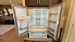 Una cocina moderna con refrigerador empotrado, microondas y pileta.