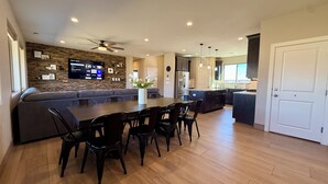 Una cocina moderna con comedor, horno empotrado y una isla grande con pileta.