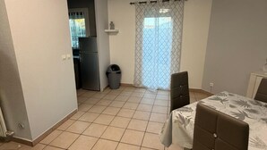 Una habitación con cama, una silla, una pequeña cocina y baño.