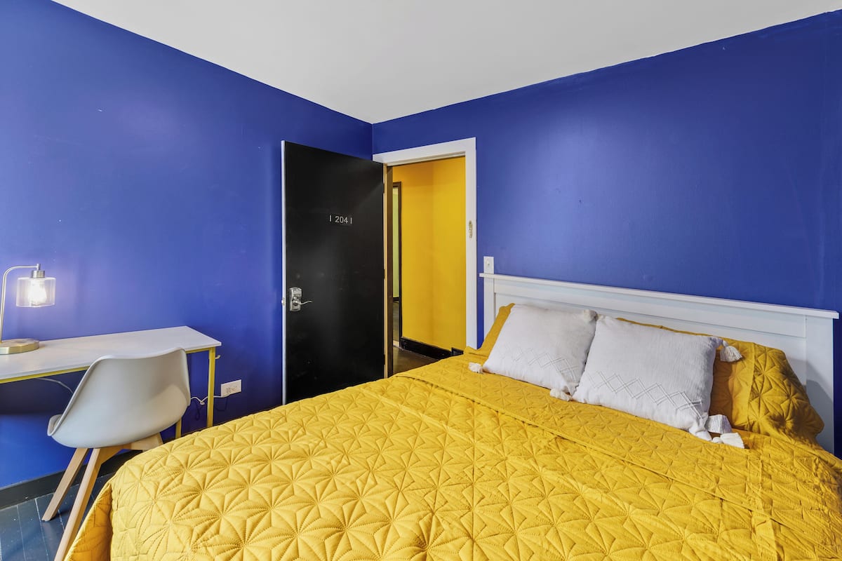 A room with a bed, a desk, and a chair.