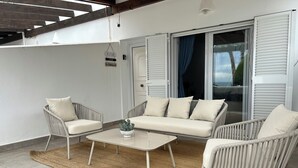 A patio with wicker furniture, a white sofa, and a coffee table. - Luxury house in MOJÁCAR (Mojácar)