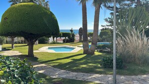 A well-maintained garden with a swimming pool, palm trees, and a clear view of the ocean. - Luxury house in MOJÁCAR (Mojácar)