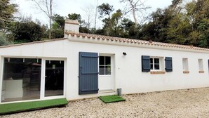 A single-story building with a white exterior, a tiled roof, and a gravel driveway. - La maison des conches - ref 803 (Longeville-sur-Mer)