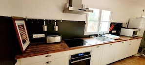 A kitchen with a toaster, microwave, sink, and cabinets.