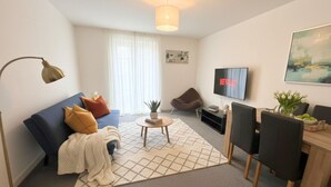 Una sala de estar moderna con un sofá, una mesa de centro y un televisor.