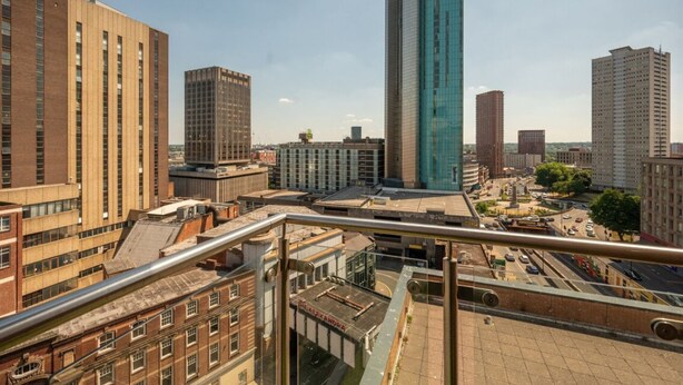 Un paisaje urbano con edificios modernos, incluyendo un imponente rascacielos de vidrio.