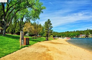 A beach with a sandy path, picnic tables, and a lake. - Cozy 3-bedroom cabin in lovely Groveland with AC (Groveland)