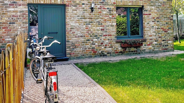 En murstensbygning med stor garageport og et lille vindue.