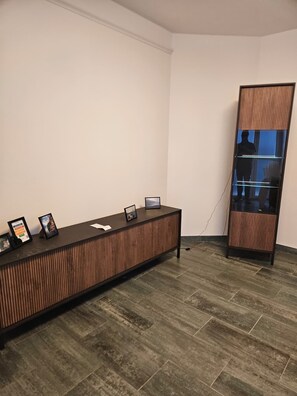 A reception desk with framed pictures, a glass partition, and a tiled floor. - Como lecco lake apartments (Malgratemalgrate)