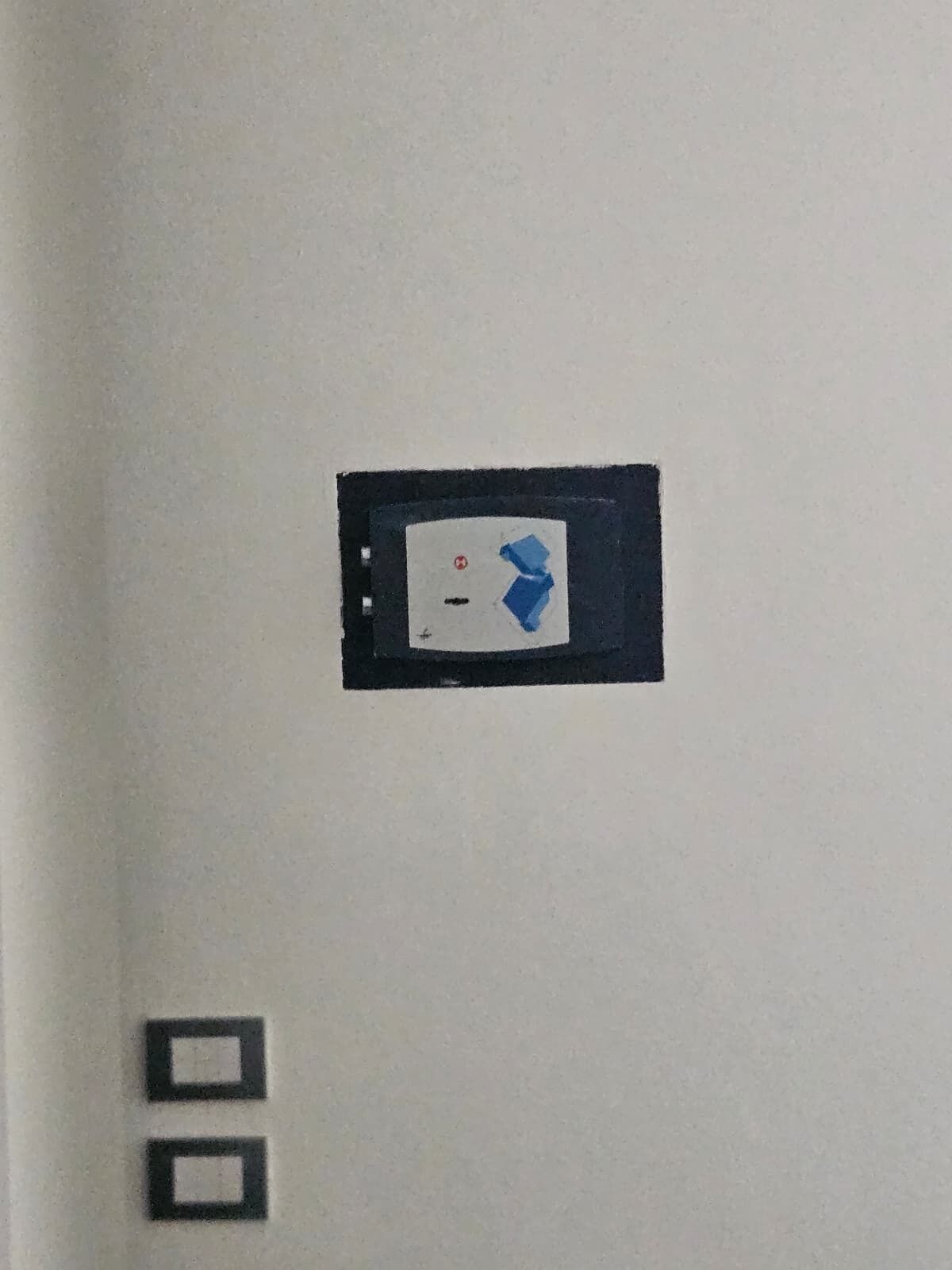 A control panel with a red emergency light and a blue button.