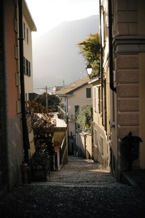 A narrow street with buildings on either side, a fire hydrant, and a staircase leading to a higher level. - Como lecco lake apartments (Malgratemalgrate)