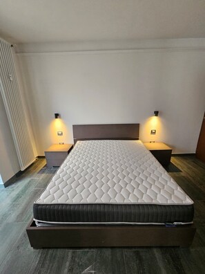 A modern bedroom with a large bed, two bedside tables, and wall-mounted lights. - Como lecco lake apartments (Malgratemalgrate)