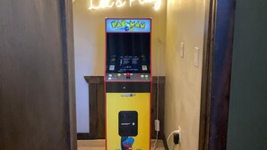 A Pac-Man arcade machine in a hallway with a neon sign above that reads "Let's Play." - Cozy Fall Retreat*Near Dollywood/Island*HotTub*Xbox (Pigeon Forge)