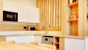 Une cuisine moderne avec des armoires blanches, un plan de travail en bois et un lave-vaisselle encastré.