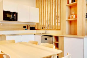 Eine moderne Küche mit weißen Schränken, einer Holz Arbeitsplatte und einem eingebauten Geschirrspüler.