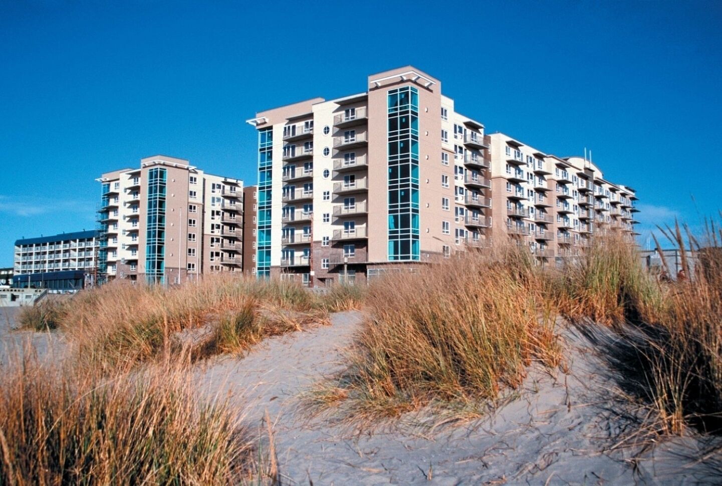A multi-story residential building with a modern architectural design, featuring balconies and large windows.