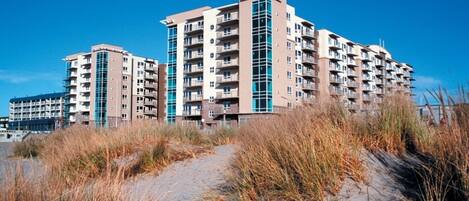 A multi-story residential building with a modern architectural design, featuring balconies and large windows.