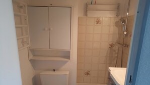 Ein kleines Badezimmer mit Toilette, Dusche und Waschbecken.