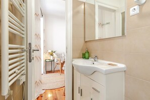 A bathroom with a white sink, a mirror, and a towel rack. - GuestReady - Charming Alfama studio (Lisbon)