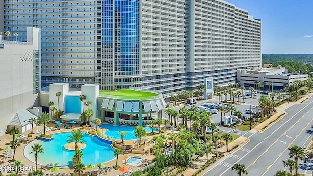 A large hotel with multiple floors, a swimming pool, and a parking area. - Blue Skies and Gulf Breezes! Enjoy Blue Serenity at LTW Nice Gulf View balcony (Panama City Beach)