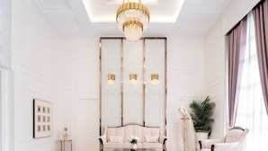 A modern living room with a chandelier, a sofa, a coffee table, and a decorative peacock statue. - 2 Bed Room Sea View Great Place 2 (Pattaya)