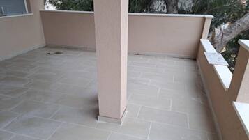 A balcony with beige walls and light grey tiled flooring.