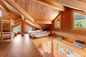 A wooden cabin with bunk beds, a loft bed, and a view of the forest. - Large chalet for 14 people + private Nordic hot tub, Alps, ski-in/ski-out (Saint François Longchamp)