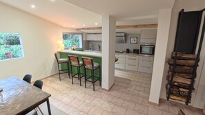 A modern kitchen with a bar area, a dining table, and chairs. - Les Salines de Réals - In the heart of the garrigue, ideal for a quiet interlude (Cessenon sur Orb)